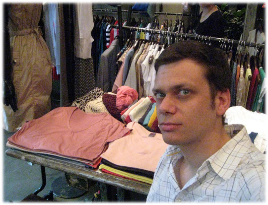 Photo of a young German man waiting for the Korean woman to finish her shopping tour. Bild eines Mannes der in einem Second Hand Laden in Seoul, Südkorea, sitzt.