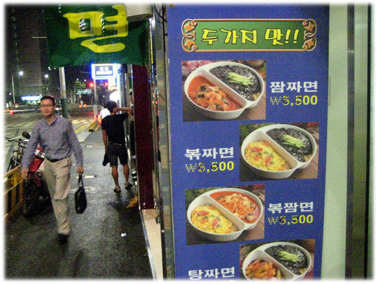 This picture shows an advertisment for Korean restaurant food with two dishes on the same table. Das Bild zeigt die Werbung eines koreanischen Pubs mit zwei Speisen pro Teller
