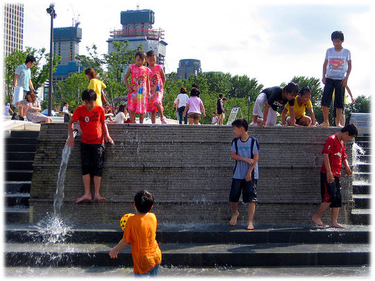 Picture of children playing with water at Han River park in the city of South Korea. Koreanische Kinder spielen mit Wasser auf einem Spielplatz in Seoul