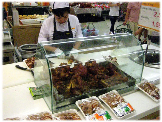 Fresh food are prepared by Korean women so that the customers can buy fresh dishes and meals. Frische asiatische Gerichte werden für die Kunden im Markt zubereitet. Der Markt liegt in Südkorea.