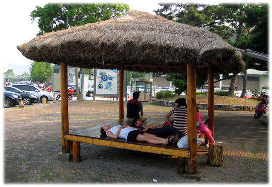 Photos of some people sitting on a wodden resting place close to the 1988 olympic stadium in Seoul. Bilder von einem Rastplatz für Familien in Südkorea
