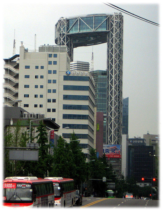 On this photo you see the Jongno tower which is a big high building full of offices. Bilder von einem großen Haus mit einer Lücke. In dem Haus sitzt das Finanzamt von Seoul.