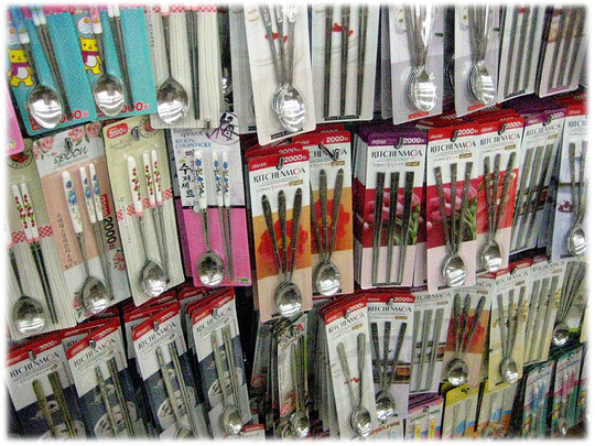 Photo of iron chopsticks at a shop at a busy shopping street. Das Bild von Stäbchen aus Metall in einem Geschäft für Haushaltsartikel in einer Einkaufsstraße.
