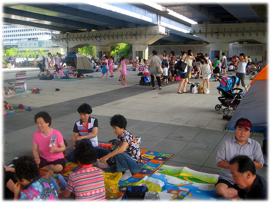 Pictures of many Koreans sitting in the shadow below a Han River bridge and enjoying the weekend. They love the shadow! Die Bilder zeigen Koreaner im Schatten sitzend