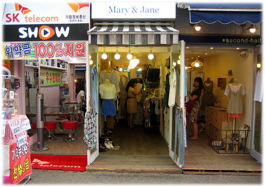 Photo of three very small shops in a shopping area for young people of Seoul. Drei kleine Läden in einer Einkaufsstraße in Seoul.