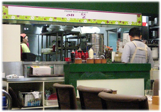 At this photo you see the kitchen of a restaurant with a big wide open window. Every guest can watch the cook cooking the food! Bilder vom asiatischen koreanischen Kochen in einer Küche