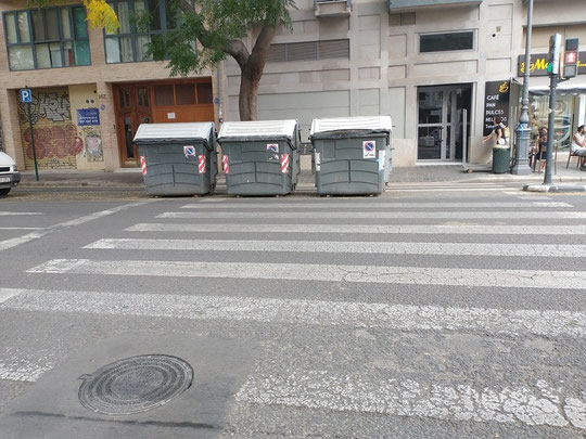 En la C/ Guillen de Castro y al lado del Museo de prehistoria de Valencia, existe un paso de cebra o peatones en donde han colocado varios contenedores de residuos urbanos.