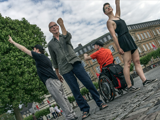 Bild: Vier Queers stellen das geplante Denkmal nach
