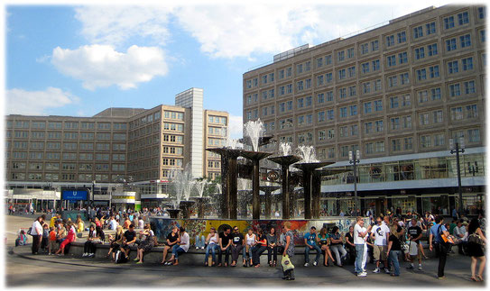 Bilder vom Alexanderplatz in Berlin. Das Foto zeigt den Brunnen der Völkerfreundschaft mit Touristen, Einheimischen und Punks, die auf dem Brunnenrand sitzen. Bilder von der DDR und Ost-Berlin.