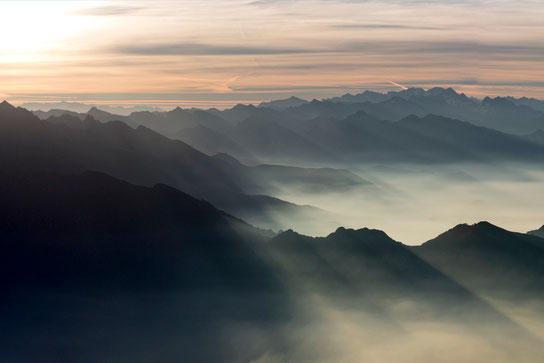 Horizontal photo with the sun rising over the mountains seen from the top of Grigna in june
