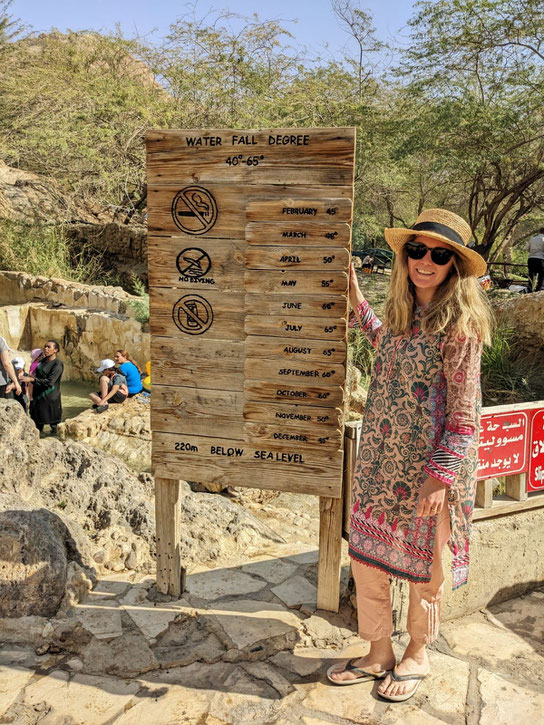 A wooden sign shows the water temperatures 