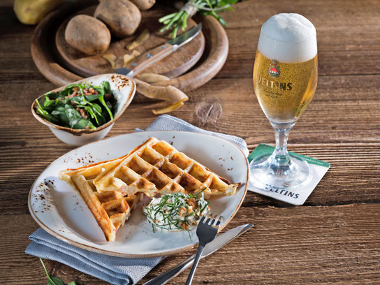 Bei Speckwaffeln mit Petersilien-Nuss-Creme handelt es sich um eine genussvolle, herzhafte Vorspeise. Ein erfrischendes Pils ist dazu die richtige Kombination. Foto: djd/Brauerei C. & A. Veltins