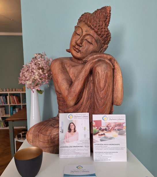 Buddhafigur mit Flyern von Heilpraktiker Praxis und Kochstudio Stephanie Leßmann