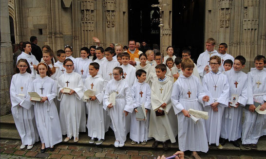 A la sortie de la basilique, les jeunes de l'école Notre-Dame entourent le P. Stéphane qui a présidé la célébration