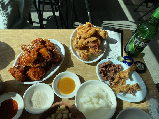 tavolaimbandita con pollo fritto doppia salsa, birra Terra e piattini di salse locali coreane in un ristorante di Suwon