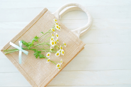 ジュードバッグの上に置かれたカモミールの花。リボンで束ねられている。