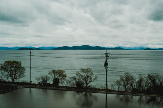 湖西線に沿う琵琶湖沿岸に水田。対岸の山は意外に近く感じられます。
