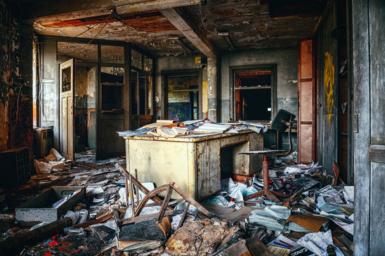 Ein verwahrlostest und zerstörtes Büro, wo Papier und kaputte Möbel auf dem Boden liegen. Bild von Peter H auf Pixabay