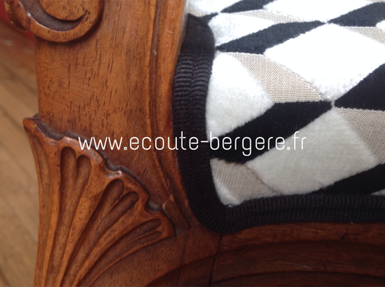 Détail du double passepoil noir et velours géométrique noir et blanc graphique sur un tabouret curule de style Louis XV, restauration réalisée par Ecoute Bergère