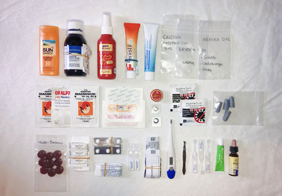 Medikamente für die Reiseapotheke aufgereiht auf einem weißen Hintergrund. Damit ist man im Urlaub ausgrüstet. Ob Verletzung, Erkältung oder Allergie, die richtigen Medikamente sind dabei!