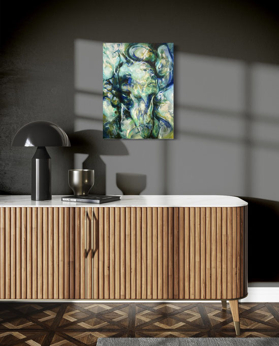 Abstract schilderij met organische vormen in blauw-, groen- en wittonen, hangt aan een donkere muur in een stijlvol ingerichte ruimte met een houten kast met verticale lamellen en een modern zwarte tafellamp
