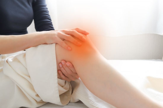 膝が痛み手を当てる女性