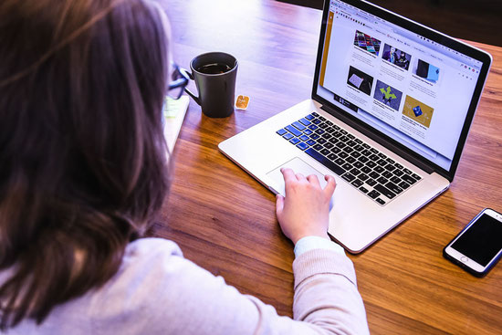 Boardmaker deutsch - Eine junge Frau schreibt etwas auf ihrem Laptop