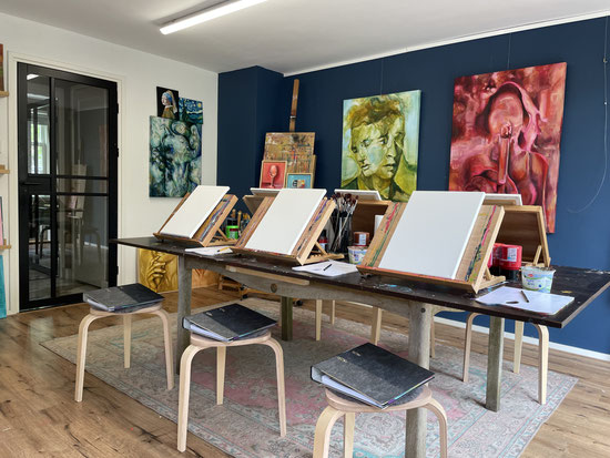 Sfeervol atelier van Daphne Schrijver in Breda, ingericht voor een schilderworkshop met ezels, doeken en moderne kunst aan de muur.