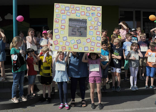 Die Kinder haben ein Geschenk für ihre Schule.