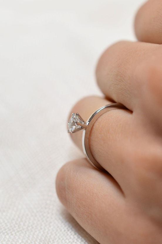 bague de fiançailles en or blanc18k diamant brillant serti 6 griffes portée sur main de femme