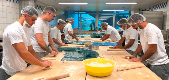 Teilnehmer formen Gebäckstücke in Küche