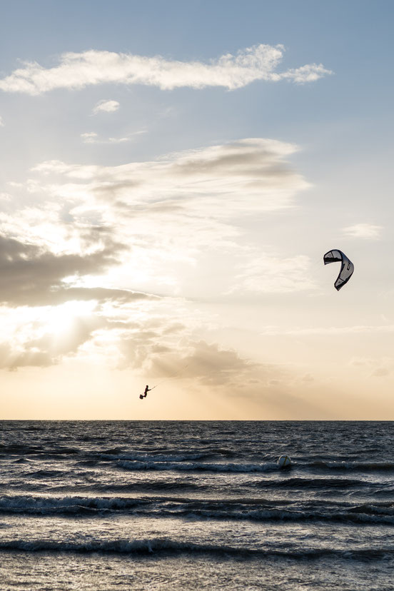 Kite surfer jumping at sunset