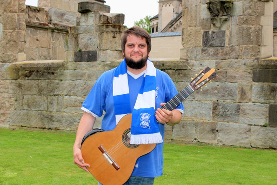 Russell Poyner mit Birmingham-Trikot und Gitarre in Koblenz