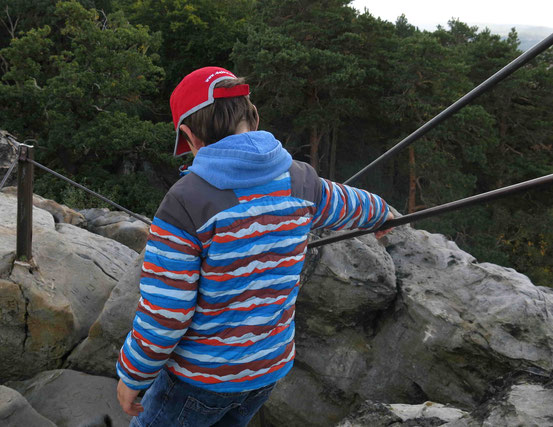 Kind steigt von Großvaterfelsen bei Blankenburg ab, hält sich am Geländer fest
