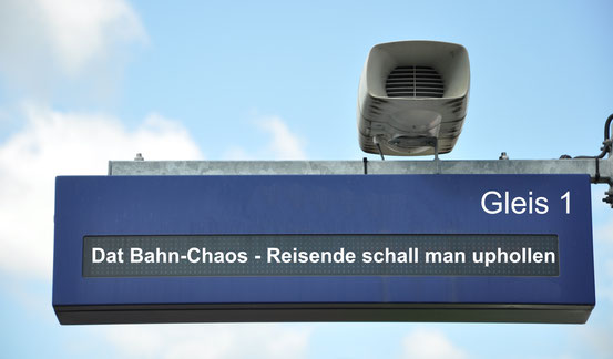 Bahnhofs-Anzeigetafel mit der Aufschrift: Dat Bahn-Chaos - Reisende schall man uphollen