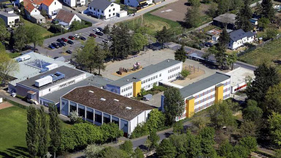 Von Grün umgeben: Bürgerhaus, Kindertagesstätte, Sporthalle und Grundschule hängen baulich zusammen. Luftbild: Axel Häsler © Axel Haesler