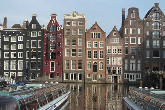 facciate dei palazzi di Amsterdam affacciati su canale con barche