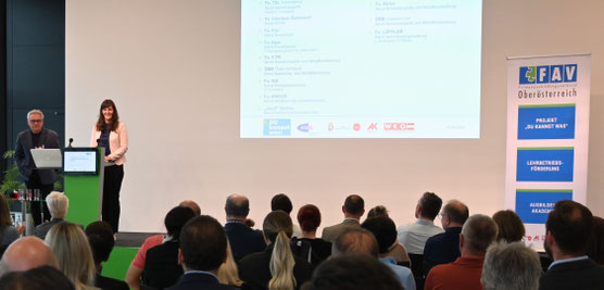 Sandra Illibauer spricht beim Podium, Präsentation im Hintergrund