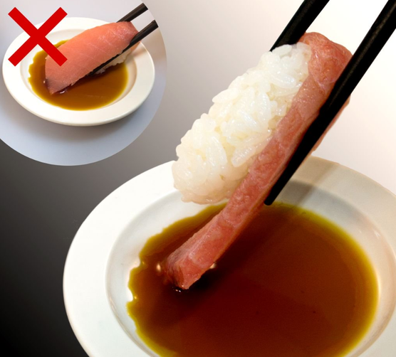 Close-up of hands eating nigiri sushi with proper soy sauce dipping