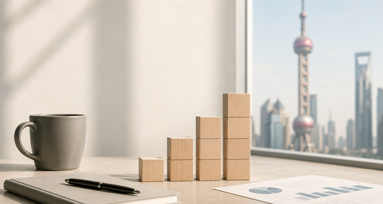 Minimalist executive office workspace with financial charts, rising wooden blocks and a view of Shanghai, illustrating expatriate compensation trends, costs and hiring considerations in China.
