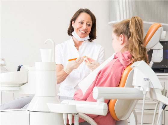 Prophylaxefachkraft Karin Müller erklärt Patienten die richtige Zahnreinigung
