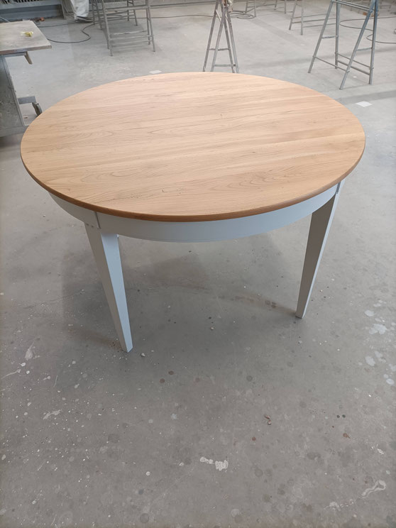 Table ronde de salon en merisier. Décapée puis vernis pour le plateau. Les pieds ont été laqués.