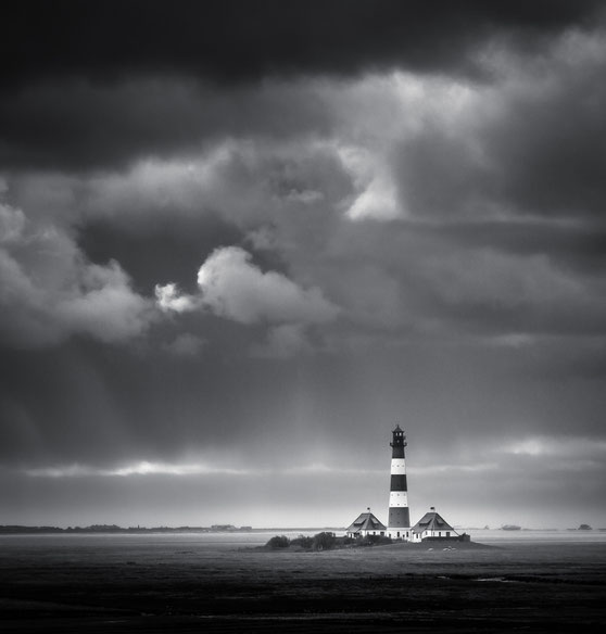 Schwarz-weiß Foto vom Leuchtturm Westerheversand im gleichnamigen Westerhever an der Nordseeküste bei stürmischem Wetter