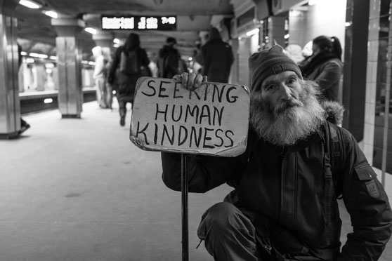 man-holding-card-with-seeking-human-kindness