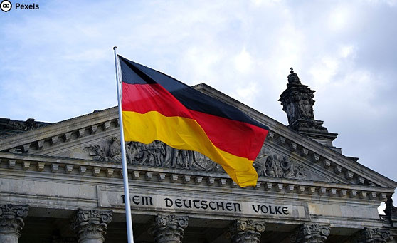 Vor dem Bundestag weht die Deutschlandfahne in schwarz-rot-gold. Foto von Ingo Joseph von Pexels.