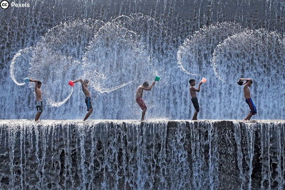 Fünf Jungs spielen auf einem Wasserfall. Foto von Jeffry S.S. auf Pexels.