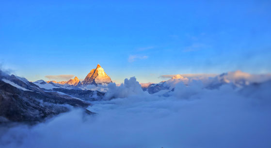 Sonne auf Gipfel über den Wolken, Burnout- Prophylaxe bei Traumatherapie oder Coaching