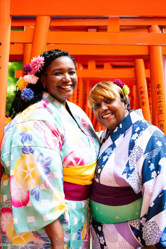 Portrait of women in kimono beneath red torii gates at Nezu Shrine in Tokyo