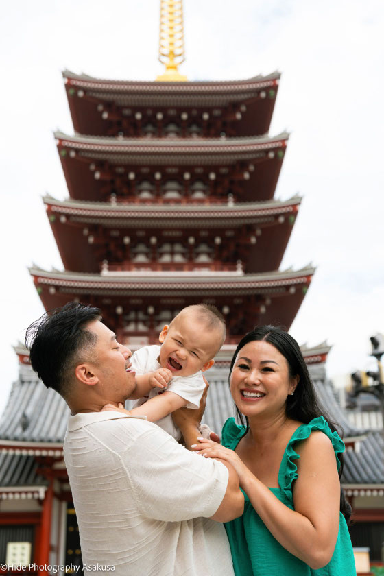 Happy family with baby in front of the five-story pagoda at Sensoji Temple in Asakusa Tokyo