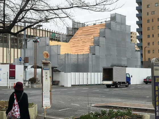 ☆JR中央線国立駅南側ロータリーから見た赤い三角屋根の旧駅舎復旧工事中の姿。仮囲いとシートに覆われていますが三角屋根が見えています。